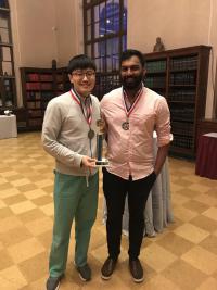 Two residents standing with trophy.